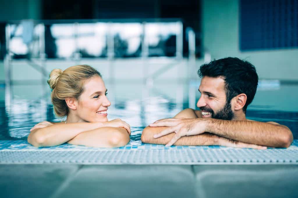 Romantisch koppel aan rand van zwembad luxe weekendje weg