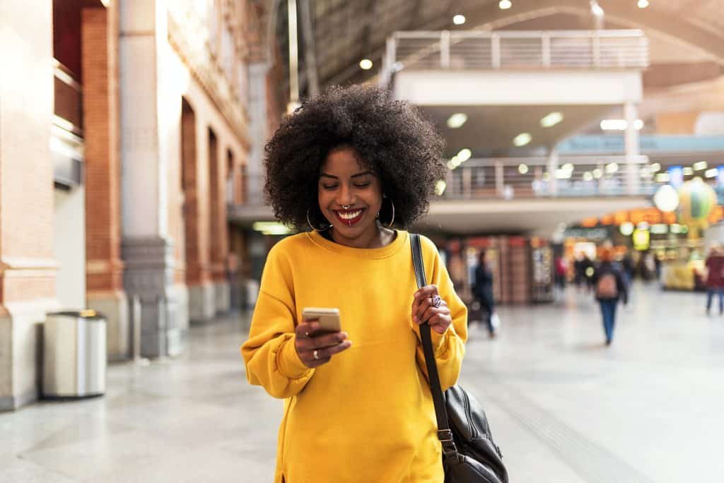 vrouw gebruikt app op telefoon in het openbaar