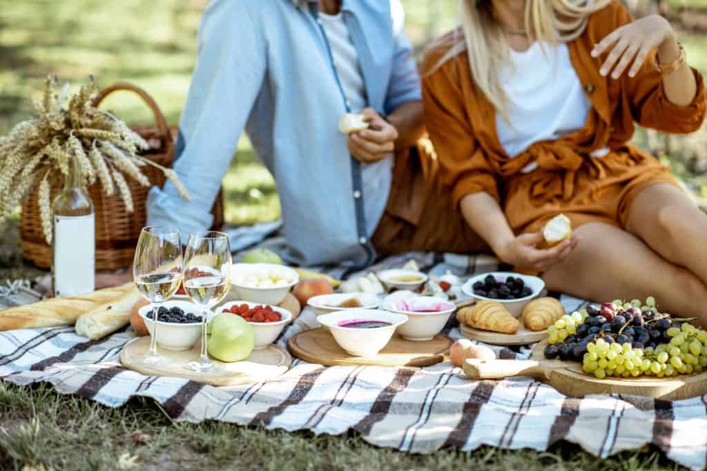 Koppel dat romantische eerste date heeft met ontbijt buiten tijdens een picknick