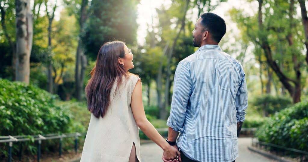 Koppel, hand in hand en pratend of wandelend in het park