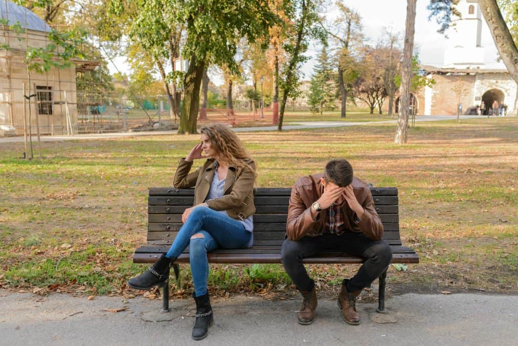 Stel negeert elkaar op een bank in het park - rebound relatie